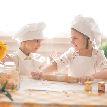 happy little children in the form of a chef to cook a delicious breakfast the kitchen