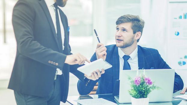 business partners discuss the profits before signing the contract in the workplace in a modern office.the photo has a empty space for your text