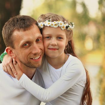 fatherhood - happy father and little daughter hugging each other in the Park on a Sunny day