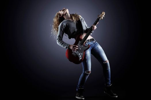 Young and beautiful rock girl playing the electric guitar.the photo has a empty space for your text