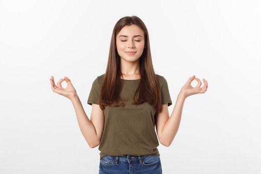 Beautiful young woman in yoga position and meditating isolated over gray background.