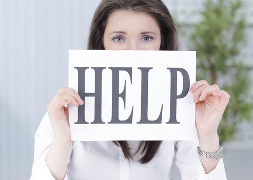 smiling business woman showing a sheet with the word help . photo with copy space