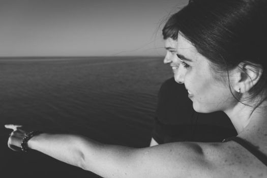 Close-up black and white portrait of a couple in love on the background of the sea in the sunset lighting. Selective soft focus