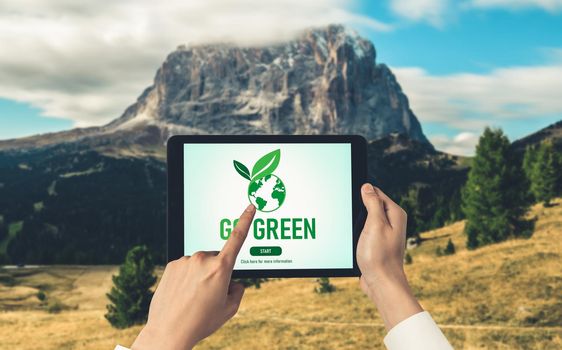 Green business transformation for environment saving and ESG business concept. Businessman using tablet to set corporate goal toward environmental friendly management and alternative clean energy use.