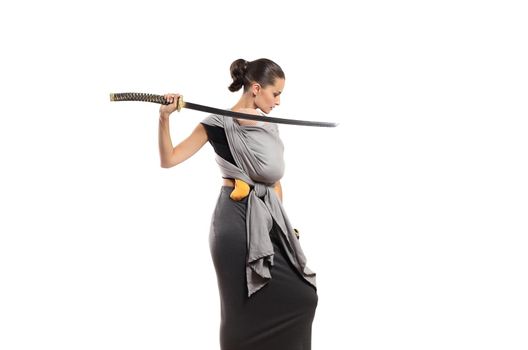 Beautiful young babywearing mother with katana sword protects her baby. Mother protection concept.