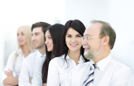 Close-up portrait of executive business people standing in a row at office and looking at the camera. Business persons.