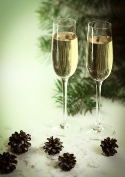 two glasses with champagne and cones on the Christmas background .photo with copy space.