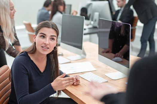 serious young woman asking a question to her colleague. office workdays