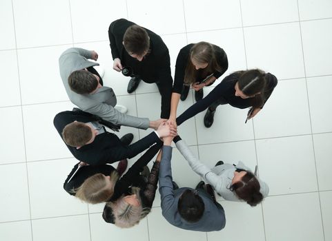 top view. a group of young business people joining their palms together. concept of teamwork