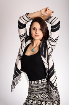 Young woman in aztec print clothes posing in white background. Portrait of young woman in aztec style. Pretty ethno fashion woman