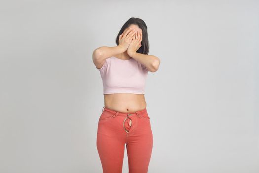 Upset young woman with slightly overweight. Diet, overweight, obesity concept.