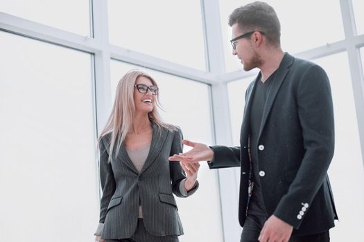 business couple discussing something standing in the office . photo with copy space