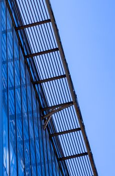 Building facade with blue sky. Glass wall in modern architecture.