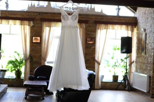 Wedding dress hanging against a wooden background