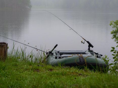 Inflatable boat with fishing rods on the lake