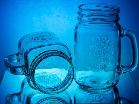 Glass jar mugs on blue and red glowing background