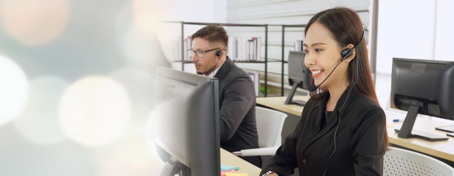 Business people wearing headset working in office to support remote customer or colleague. Call center, telemarketing, customer support agent provide service in broaden view .