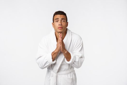 Calm spiritual handsome African guy praying. Serious peaceful young man with joining hands meditating. Belief concept.