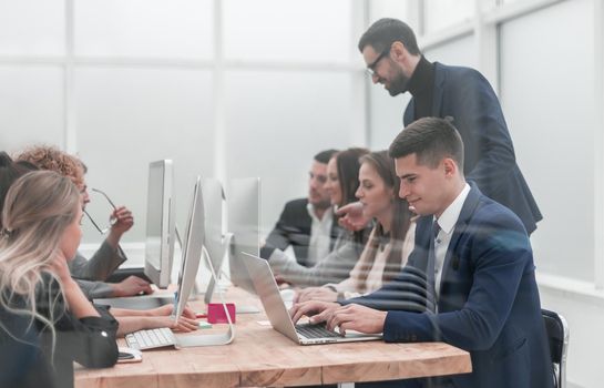 through the glass. employees work on computers in a modern office