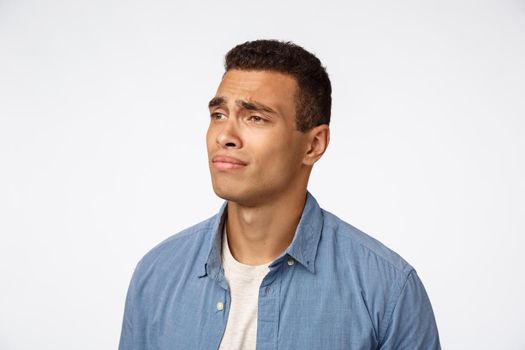 Man feeling regret, missing something interesting, dont have money, cant afford something. Disappointed gloomy, sad hispanic guy looking left, frowning express jealousy and sadness, white background.