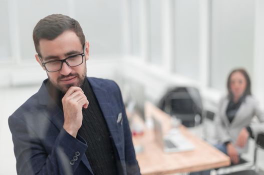 close up. brooding business man standing in office. photo with copy space