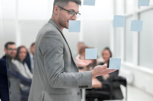 head of the project, pointing to the sticky notes during a work meeting. business concept