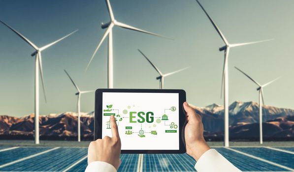 Green business transformation for environment saving and ESG business concept. Businessman using tablet to set corporate goal toward environmental friendly management and alternative clean energy use.