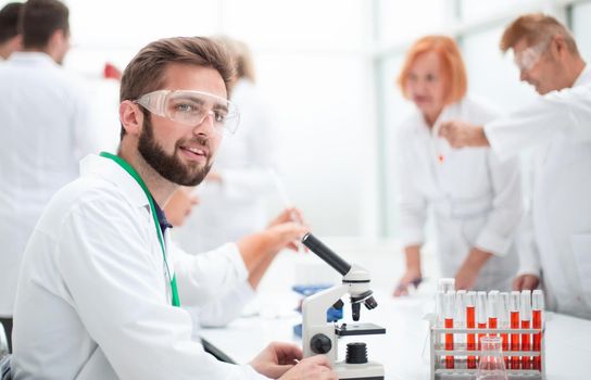 close up. young scientist is working with a microscope in the laboratory .