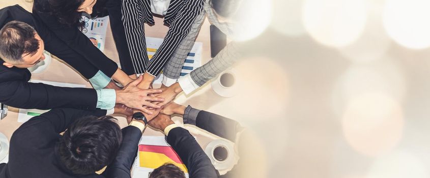 Happy business people celebrate teamwork success together with joy at office table shot from top view . Young businessman and businesswoman workers express cheerful victory in broaden view .