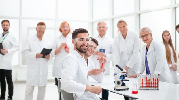 close up. smiling scientist sitting at a laboratory table .