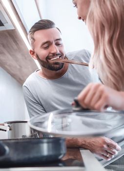 close up. young husband and wife cook dinner together