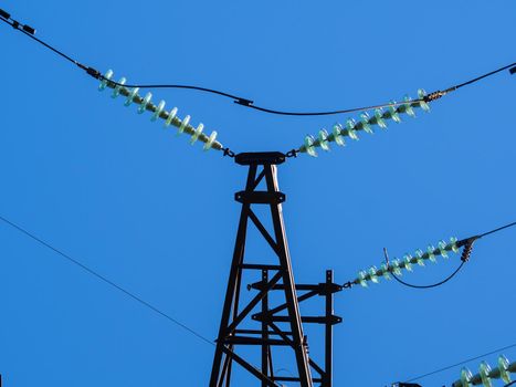 Metal pillars of power lines close up against the blue sky