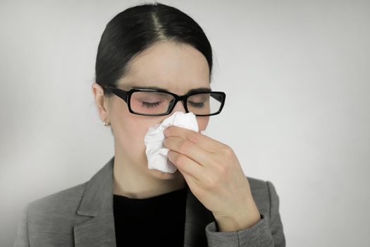 Young woman wearing glasses with flu symptoms.