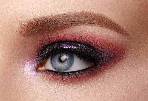 Beautiful Closeup Eye Make-up with Purple Glitter Shadows. Fashion Celebrate Makeup, Glowy Clean Skin, perfect Shapes of Brows. Shiny Shimmer