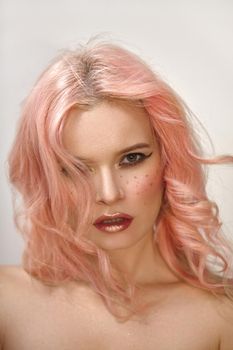 Beautiful woman with curly colored flying hair. Soft Girl style with sexy Make-up on face, red Lips and pink blush. Fresh wind of Fashion