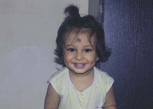 Cute Indian baby boy smiling and looking at camera.