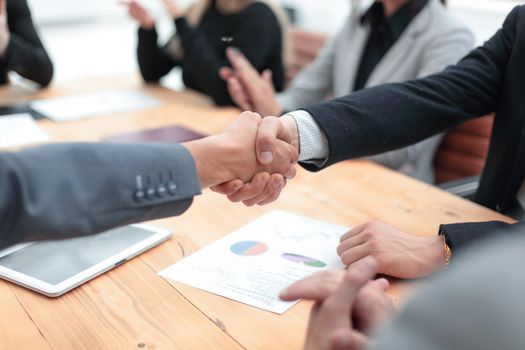 close up. business partners greeting each other at the negotiating table