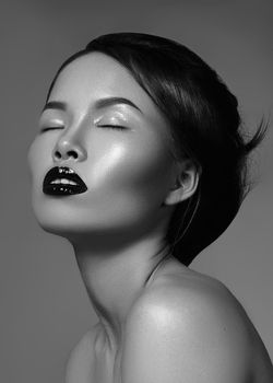 Dramatic black and white fashion portrait of beautiful asian woman. Luxury oriental model with great make-up, smooth skin, gloss lips and perfect hairstyle. Elegant evening look