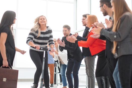 Business people take a break in the mordern office. Woman riding a scooter