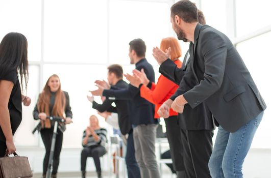 Modern business woman riding scooter in office front of colleagues in the break time