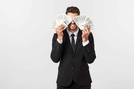 Portrait of a satisfied young businessman holding bunch of money banknotes isolated over white background