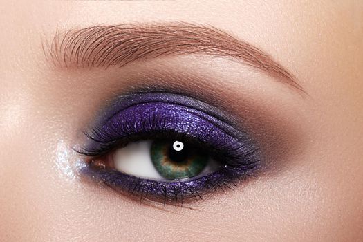 Closeup Macro of Woman Face with Purple Eyes Make-up. Fashion Celebrate Makeup, Glowy Clean Skin, perfect Shapes of Brows. Shiny Simmer