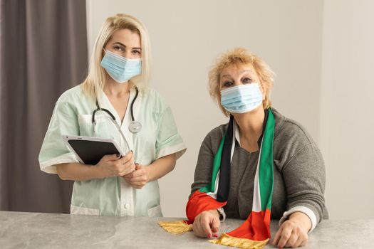 elderly woman with UAE National Flag and nurse.