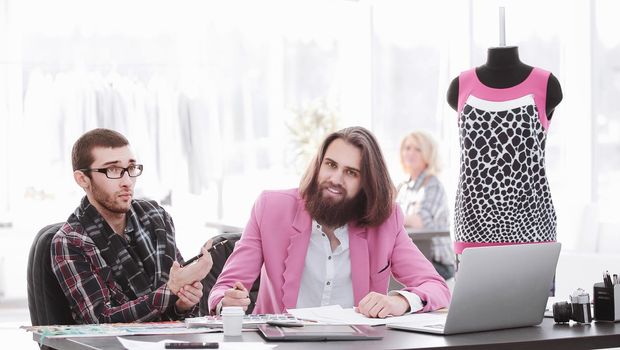 two fashion designers discussing designs of the new models.