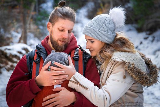 Winter outdoor walk of a young family with their newborn baby.