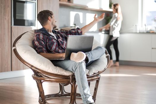 attractive guy sitting in the spacious kitchen in the morning . photo with copy space