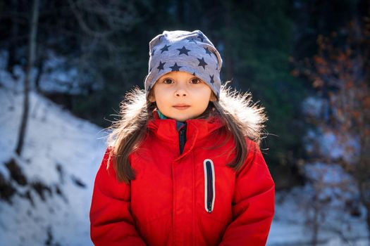 Front view portrait of 5 years old girl in winter sunny day.