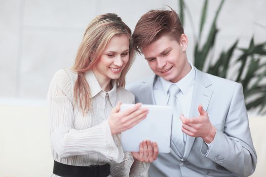 smiling business couple looking at digital tablet screen.