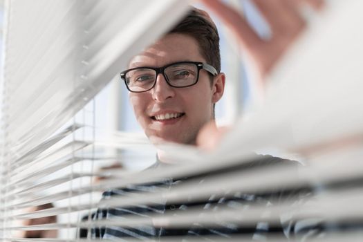 Happy businessman in office looking out the window