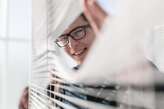 Happy businessman in office looking out the window